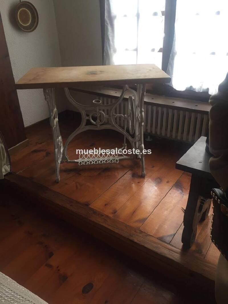 Pie de mquina coser antigua con un sobre en madera natural preparado para mesa